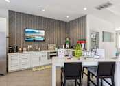Thumbnail 33 of 36 - Community kitchen with white cabinetry and beverage station at The Arbor Walk Apartments, Tampa