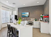 Thumbnail 34 of 36 - Modern kitchen with island seating and chevron accent wall at The Arbor Walk Apartments, Florida