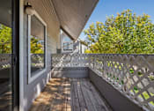 Thumbnail 24 of 44 - A wooden deck with a lattice fence and a view of a house and trees. at Windmill Apartments, Colorado, 80916