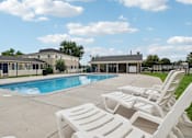 Thumbnail 40 of 56 - A pool surrounded by white lounge chairs.at Aspen Townhomes, Colorado Springs, 80909