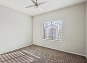 Thumbnail 62 of 105 - A room with a ceiling fan and a window at Sweetwater At Metro North Apartments, Phoenix  85029