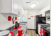 Thumbnail 35 of 57 - A kitchen with black appliances and red accents. at Millennium at Creve Coeur, Creve Coeur, 63141