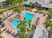 Thumbnail 24 of 31 - A pool surrounded by palm trees and lounge chairs at The Parkway at Hunters Creek, Orlando, 32837