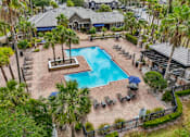 Thumbnail 25 of 31 - A pool surrounded by palm trees and lounge chairs at The Parkway at Hunters Creek, Orlando, 32837