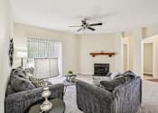 Thumbnail 1 of 32 - A living room with a grey couch, a coffee table, and a fireplace. at Cedar Springs Apartments, Raleigh, North Carolina