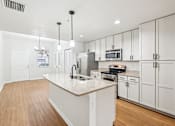 Thumbnail 5 of 64 - A kitchen with white cabinets and a wooden floor. at The Dakota, Florida, 33458