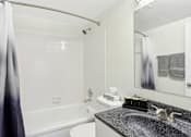 Thumbnail 38 of 57 - A bathroom with a white tub, sink, and grey tiles. at Millennium at Creve Coeur, Creve Coeur, 63141