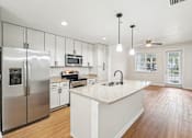 Thumbnail 4 of 64 - A modern kitchen with a refrigerator, microwave, oven, sink, and cabinets.at The Dakota, Jupiter, 33458