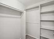 Thumbnail 61 of 105 - A white closet with shelves and a carpeted floor at Sweetwater At Metro North Apartments, Phoenix, AZ