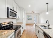 Thumbnail 2 of 64 - A kitchen with white cabinets and a granite countertop. at The Dakota, Florida