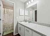Thumbnail 27 of 27 - A bathroom with a sink, mirror, and shower curtain.