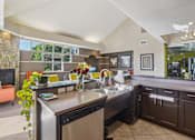 Thumbnail 21 of 41 - A modern kitchen with a large island and a dining area.