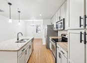 Thumbnail 3 of 64 - A kitchen with white cabinets and a granite countertop. at The Dakota, Jupiter, Florida