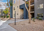 Thumbnail 71 of 105 - A tree in front of a building with a black lamp post at Sweetwater At Metro North Apartments, Phoenix, Arizona