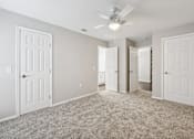 Thumbnail 25 of 27 - A spacious room with a carpeted floor and a ceiling fan.