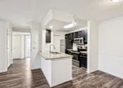 Thumbnail 9 of 31 - A kitchen with a white island and dark wood floors at The Parkway at Hunters Creek, Orlando, 32837