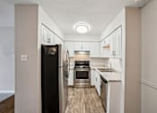 Thumbnail 4 of 40 - A kitchen with a black refrigerator and white cabinets. at Glen at Lakewood, Colorado