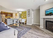 Thumbnail 3 of 41 - A modern living room with a grey couch and a fireplace.