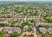 Thumbnail 8 of 27 - A bird's eye view of a suburban neighborhood with houses and a pool.
