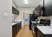 Thumbnail 15 of 27 - A kitchen with black cabinets and white countertops.