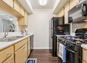 Thumbnail 19 of 41 - A kitchen with a black refrigerator and stove. at University Park Apartments, Orlando, FL