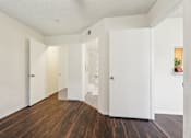 Thumbnail 23 of 41 - A hallway with white walls and wood floors. at University Park Apartments, Orlando, FL, 32817