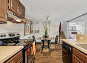 Thumbnail 4 of 43 - Kitchen with brown cabinets at Whisper Lake Apartments, Winter Park, FL