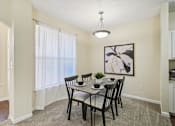 Thumbnail 7 of 32 - A dining room with a table set for four. at Cedar Springs Apartments, Raleigh, NC