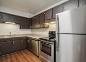 Thumbnail 7 of 56 - A kitchen with a stainless steel refrigerator, oven, and sink. at Aspen Townhomes, Colorado Springs, 80909