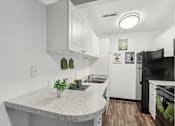 Thumbnail 17 of 57 - A kitchen with a granite countertop and white cabinets. at Millennium at Creve Coeur, Missouri, 63141