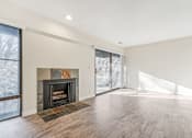 Thumbnail 26 of 62 - A large, empty room with a fireplace and wood flooring. at Cliffs at Canyon Ridge, Utah, 84401