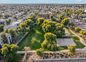Thumbnail 105 of 105 - A park with a basketball court surrounded by trees and houses at Sweetwater At Metro North Apartments, Phoenix  85029