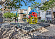 Thumbnail 45 of 51 - A playground with a red and yellow slide and a blue and yellow playhouse.