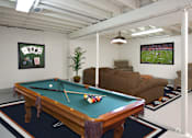 Thumbnail 10 of 56 - A pool table in a room with a TV showing a football game.