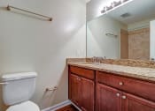 Thumbnail 3 of 24 - Bathroom with a toilet sink and mirror at River Crossing Apartments, Georgia
