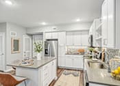 Thumbnail 4 of 86 - a white kitchen with stainless steel appliances and white cabinets at Edge75, Naples, Florida 34104