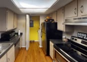 Thumbnail 3 of 20 - a kitchen with white cabinets and black appliances and a yellow door at Brookstone Village, Cincinnati