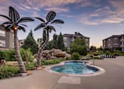 Thumbnail 34 of 45 - a swimming pool with palm trees in front of apartment buildings at Heritage at Stone Mountain, Northglenn, CO, 80233