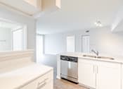 Thumbnail 48 of 117 - a kitchen with white cabinets and a stainless steel dishwasher at Heritage Bay, Jensen Beach Florida