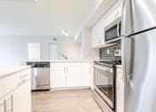 Thumbnail 46 of 117 - a kitchen with white cabinets and stainless steel appliances at Heritage Bay, Florida, 34957