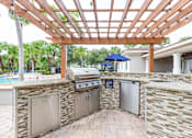 Thumbnail 85 of 117 - an outdoor kitchen with a pergola and a pool in the background at Heritage Bay, Florida, 34957