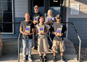Thumbnail 61 of 62 - A group of people stand outside a leasing office holding certificates at Cliffs at Canyon Ridge, Ogden, UT, 84401