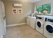 Thumbnail 50 of 51 - A laundry room with a washer and dryer, a refrigerator, and a window.