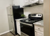 Thumbnail 4 of 23 - Upgraded kitchen with a stove and a refrigerator at The Pointe at Irving Park, Greensboro, NC, 27408