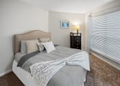 Thumbnail 5 of 43 - Bedroom with a bed and a large window at University Ridge Apartments, Durham, NC, 27707