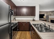 Thumbnail 11 of 43 - Kitchen with stainless steel appliances and wood flooring at University Ridge Apartments, Durham, NC, 27707