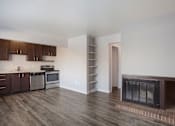 Thumbnail 13 of 50 - Empty living room with a fireplace and a kitchen   at Governor's Park, Fort Collins, 80525