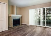 Thumbnail 2 of 31 - A living room with a fireplace and a large window at Arcadia Townhomes, Federal Way, WA