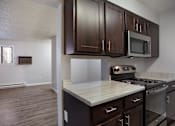 Thumbnail 7 of 50 - Empty kitchen with wooden cabinets and a stove   at Governor's Park, Fort Collins, 80525
