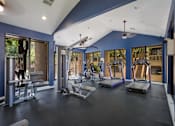 Thumbnail 17 of 23 - Gym with exercise equipment and windows at Mountain Run Apartments, Albuquerque, NM